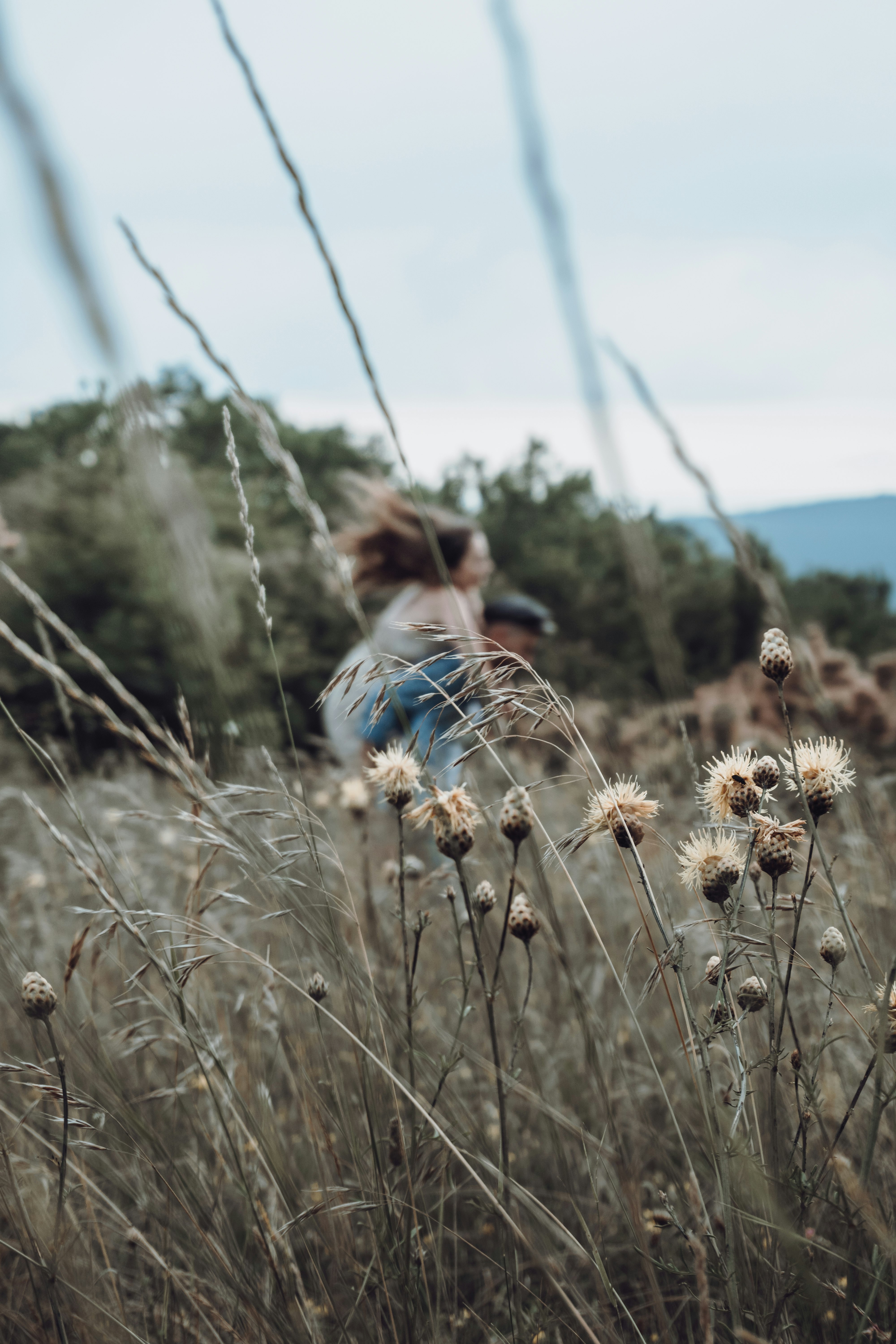 girl in blue denim jacket standing on brown grass field during daytime